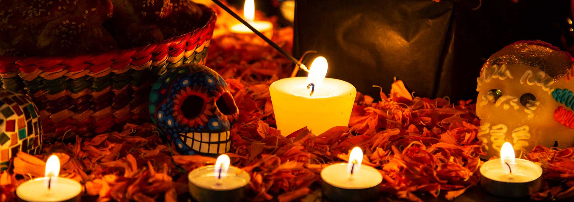 candles being lit on an ofrenda for Day of the Dead